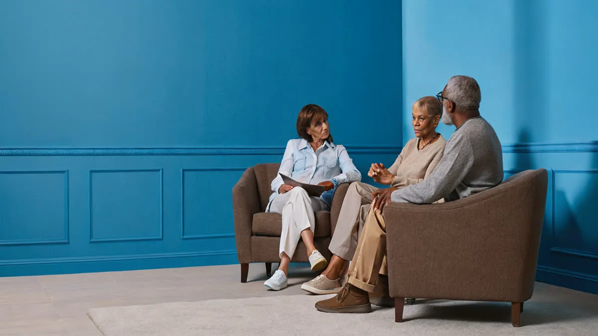 Compassionate lawyer meeting with an elderly couple and their adult child in a private office in Savannah, Georgia