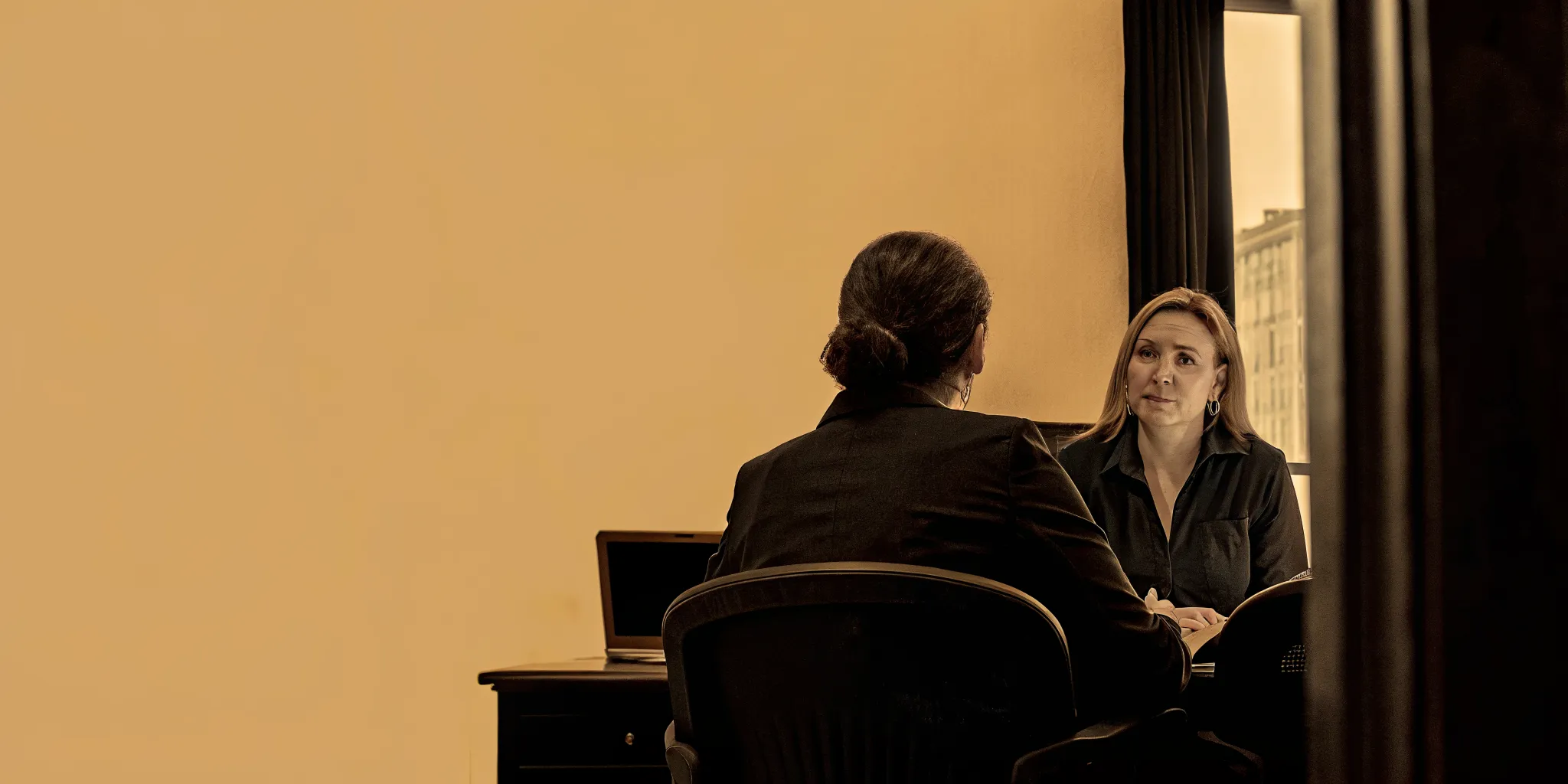 An attorney speaking with an injured client wearing an arm brace in a bright Savannah law office