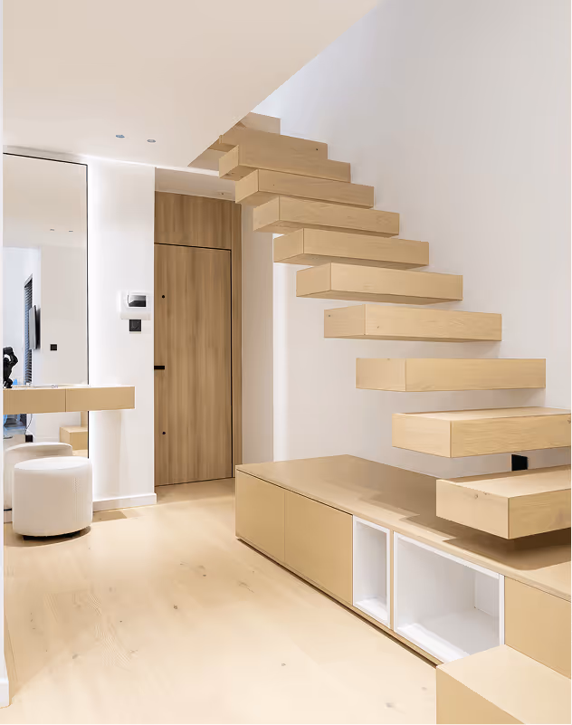 Minimalist interior with floating wooden staircase, light wood flooring, and built-in storage cabinets below.