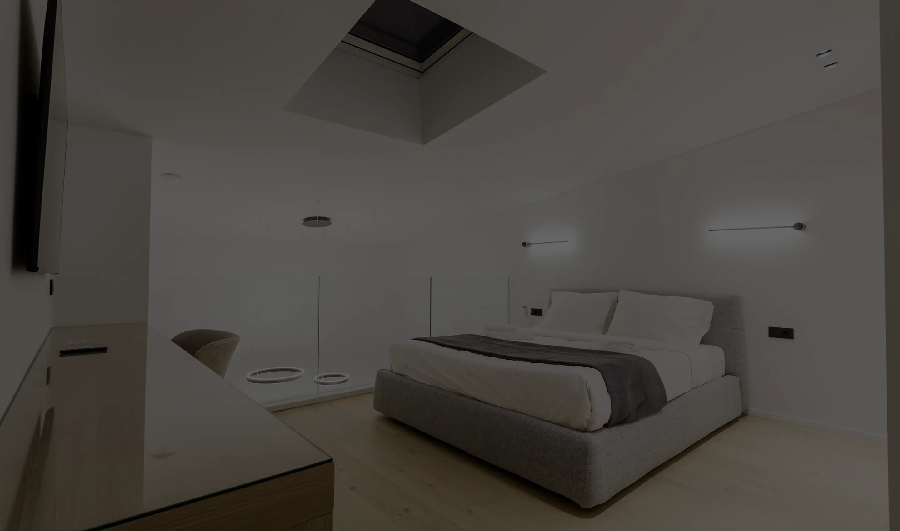 Modern minimalist bedroom with gray upholstered bed, white bedding, and wooden floor under a skylight.