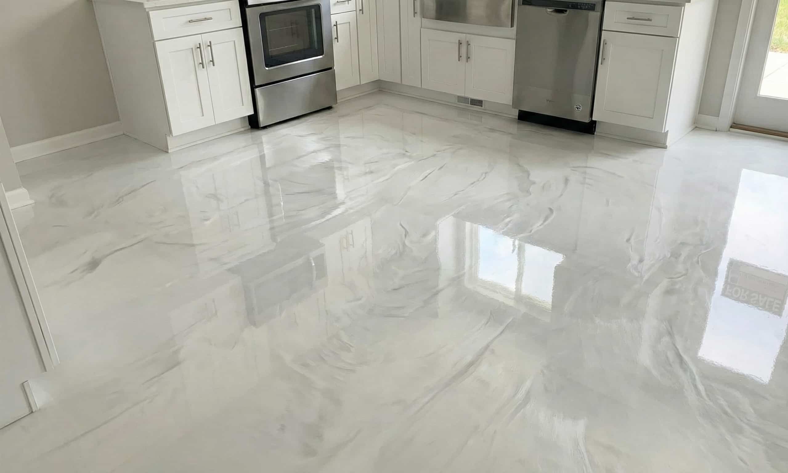 Modern kitchen with glossy white and gray marbled epoxy resin floor reflecting cabinets and appliances.