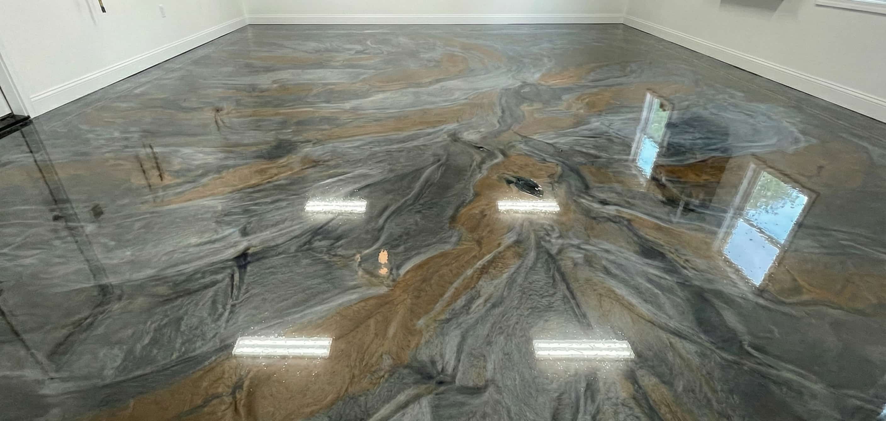 Empty room with glossy epoxy floor featuring swirling gray and brown marble-like patterns and reflections of windows and ceiling lights.