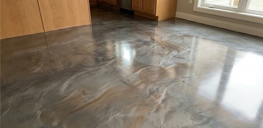 Glossy, marbled epoxy floor with brown and gray swirls in a kitchen with wooden cabinets and large windows.