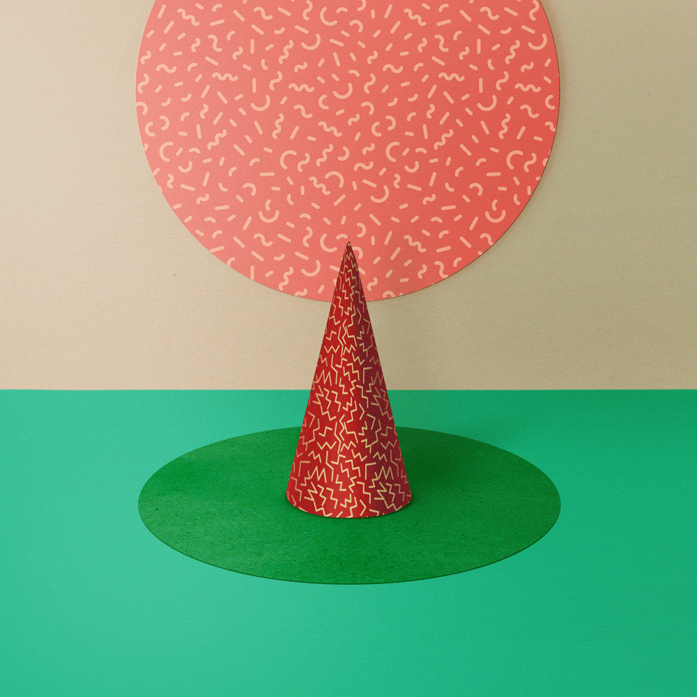 Animated craft shapes including a red cone and circle with patterns on a green surface with a beige background.