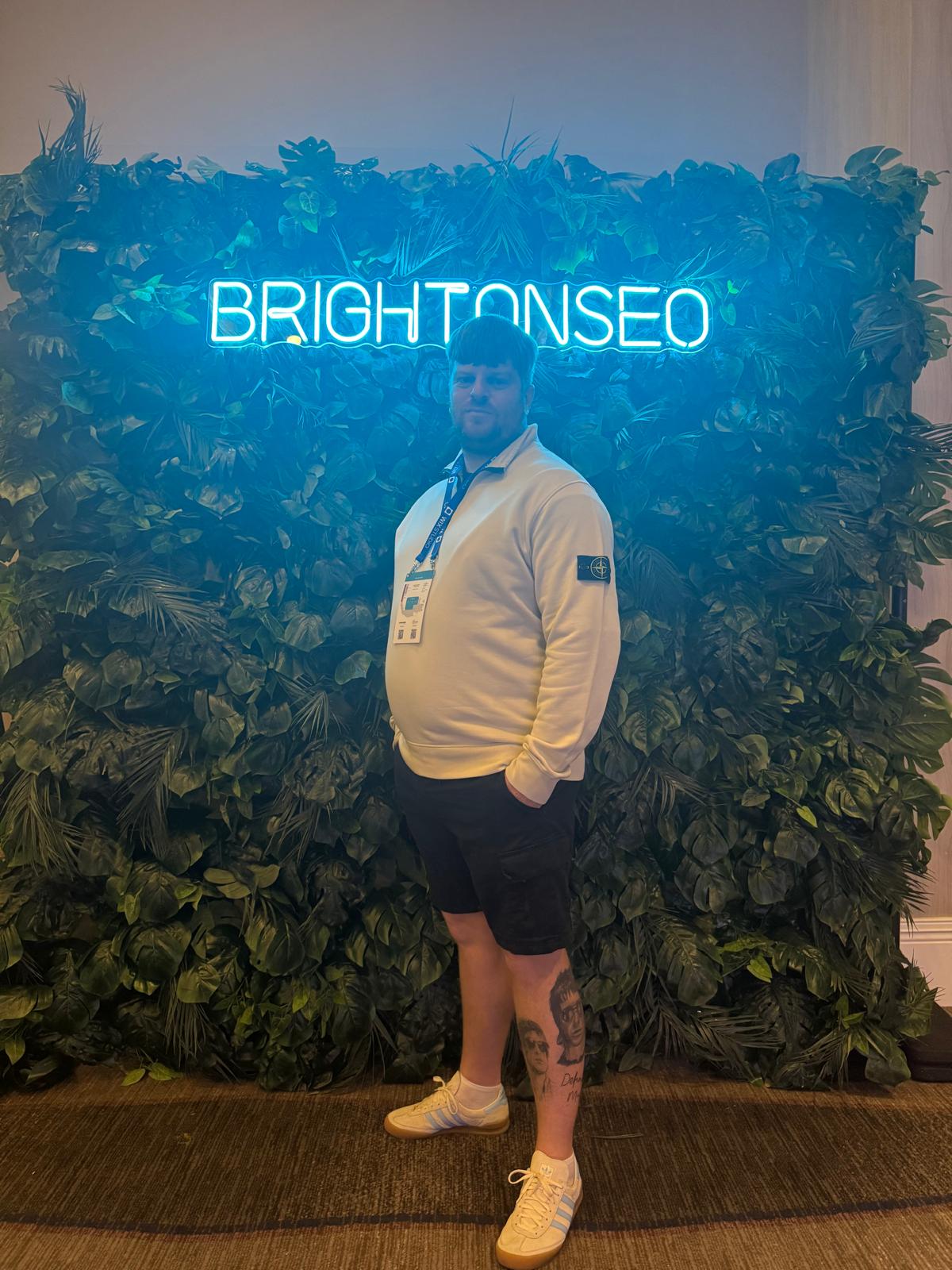 Ashley in front of BrightonSEO Sign Wall.