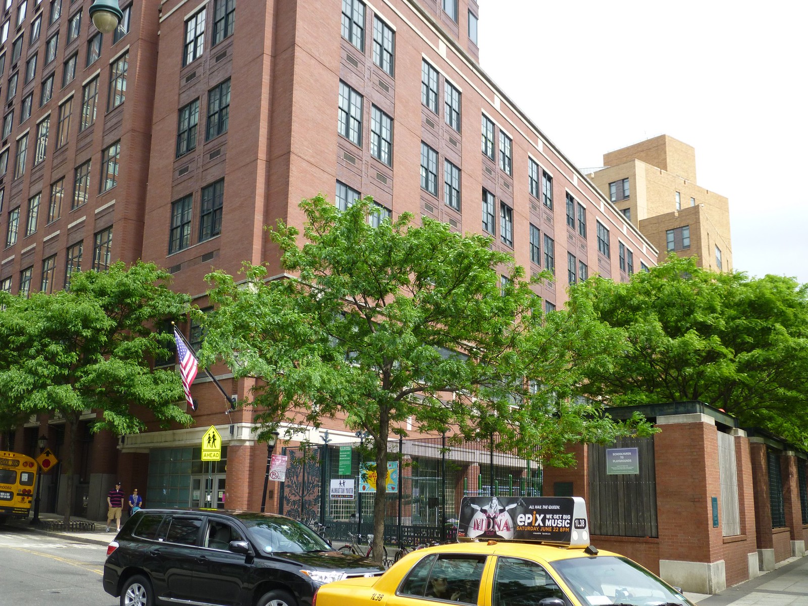 Red brick school building exterior with green trees