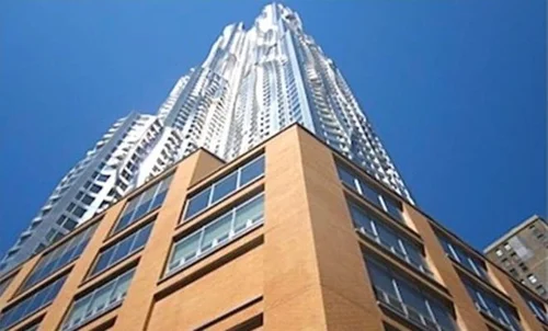 Tall residential tower with brick base viewed from street level