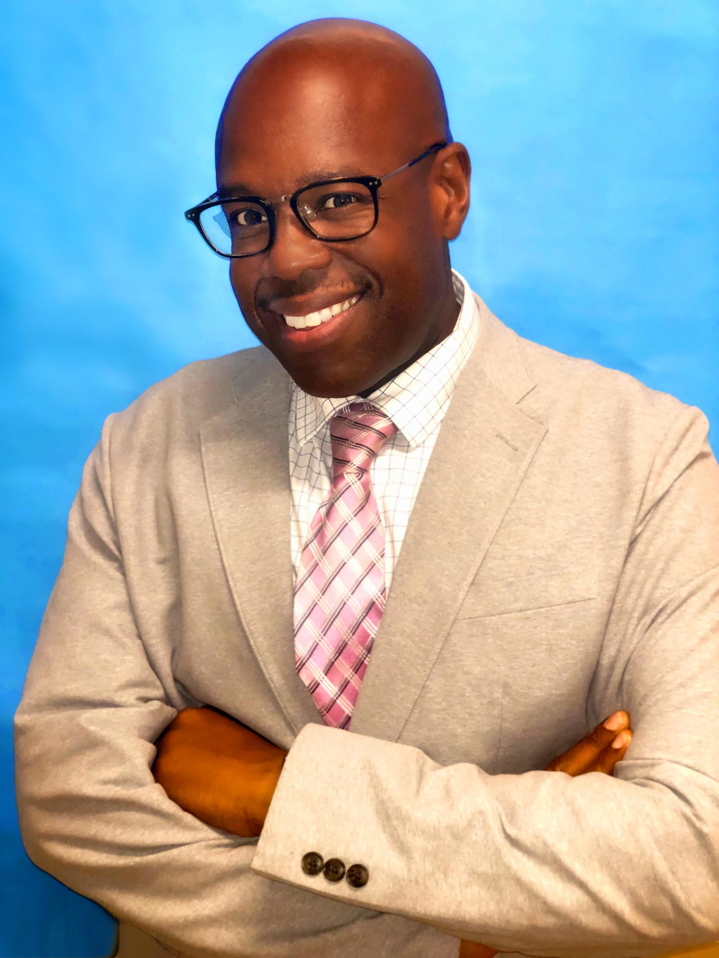 Professional headshot of staff member in tan suit