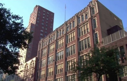 Red brick school building with multiple stories and large windows