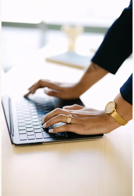 Hands of a premium virtual assistant typing on laptop keyboard, demonstrating executive virtual assistant services