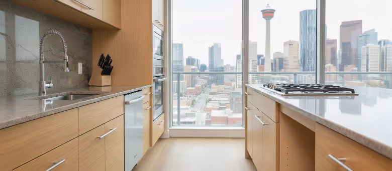 Professional Calgary handyman performing kitchen cabinet repairs and hardware upgrades in a modern downtown condo with a view of the Calgary Tower. | Quickfix Handyman Inc.
