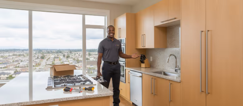 Professional handyman in Calgary standing in a modern kitchen with a view of the Calgary Tower, offering appliance installation and kitchen repair services. | Quickfix Handyman Inc.