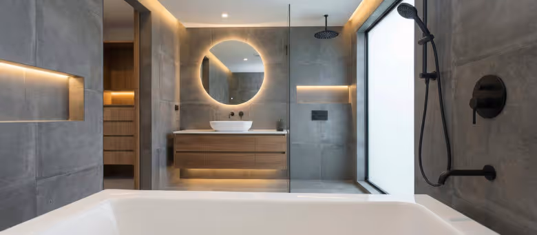 Modern luxury bathroom with grey large-format tiles, featuring professional caulking and grout refresh services for a seamless, mold-resistant finish in a Calgary home. | Quickfix Handyman Inc.