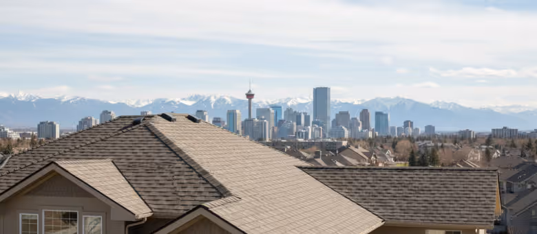 Completed residential roof repair and new asphalt shingle installation in Calgary, featuring a durable, weather-resistant finish with the city skyline and Rocky Mountains in the distance. | Quickfix Handyman Inc.