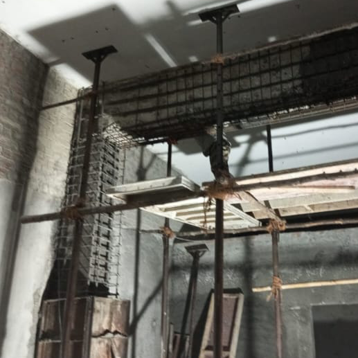 Structural strengthening work showing reinforced concrete column and beam with steel reinforcement bars