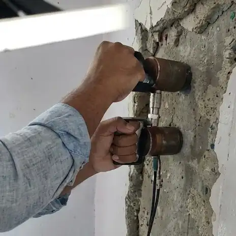 Structural Engineer performing Ultrasonic Pulse Velocity (UPV) testing on a concrete column