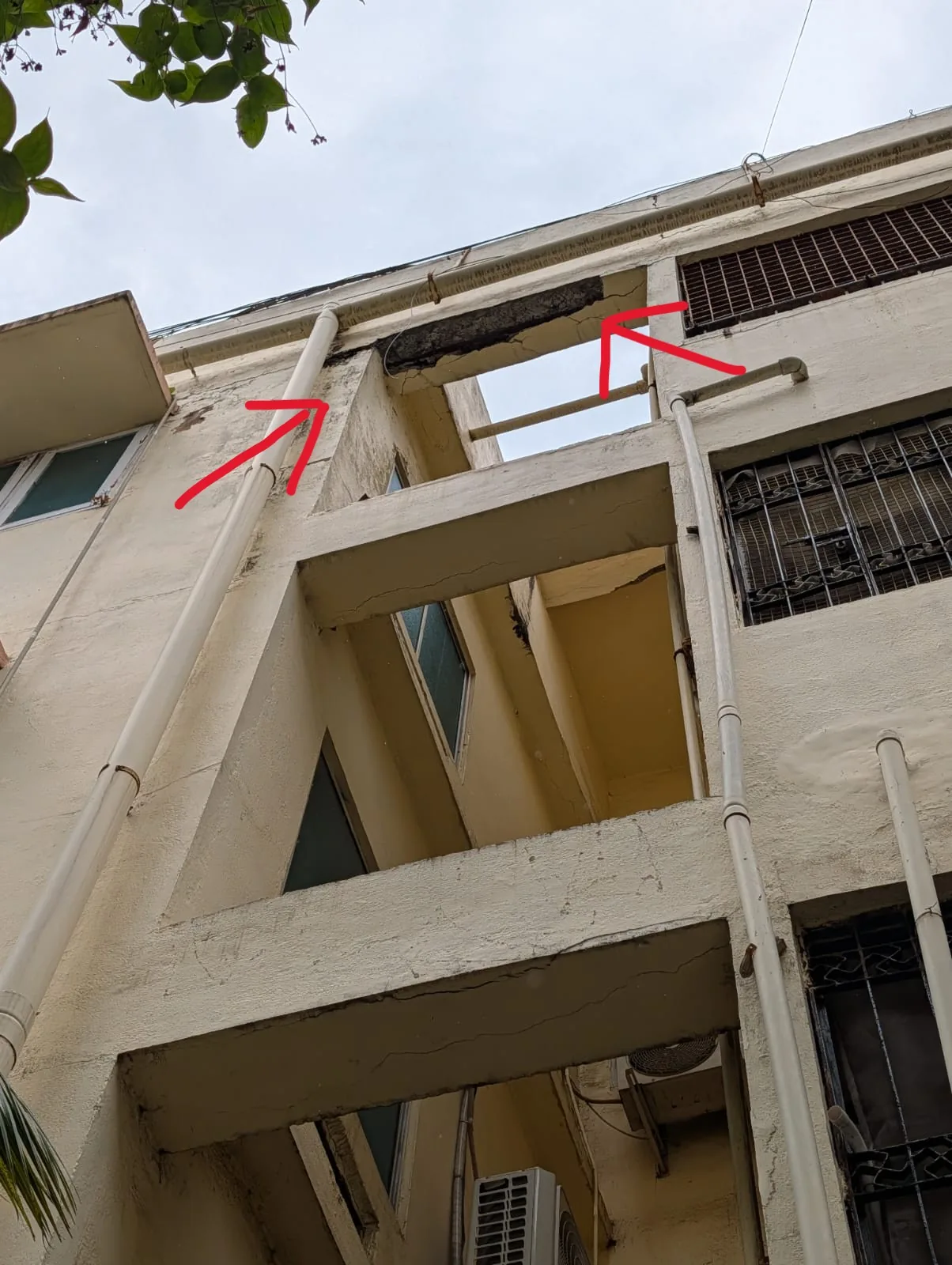 Concrete falling from beam with exposed rusted steel — apartment building structural inspection Adyar Chennai
