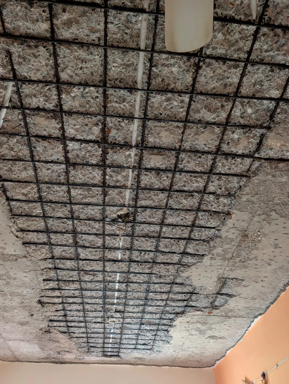 Apartment ceiling concrete delamination with full reinforcement grid exposed — structural inspection Perumbakkam Chennai