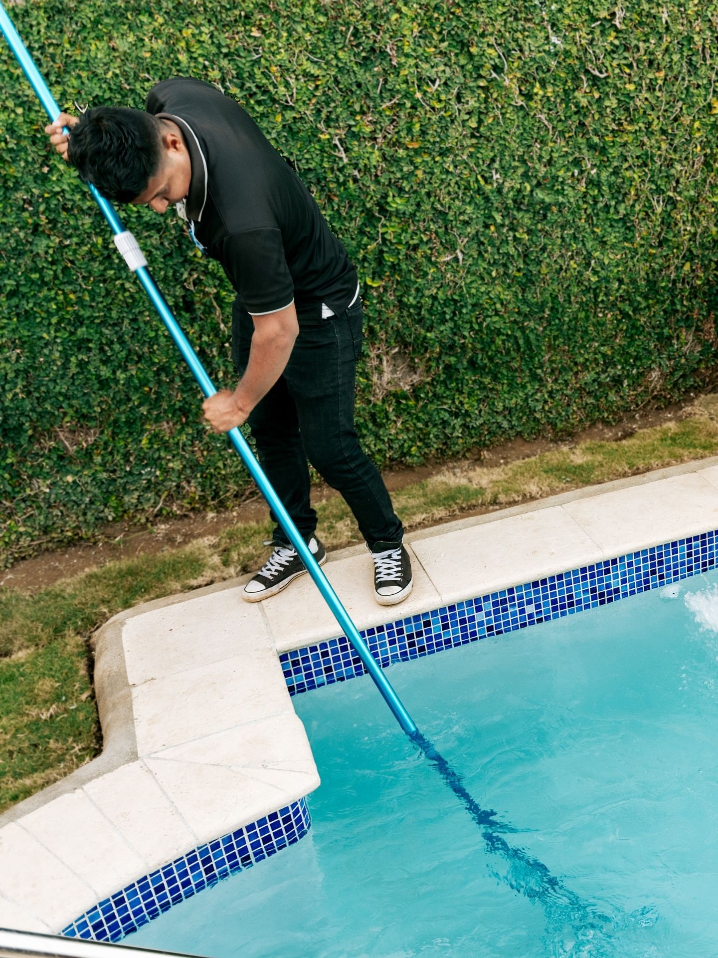 Pool technician servicing a residential pool