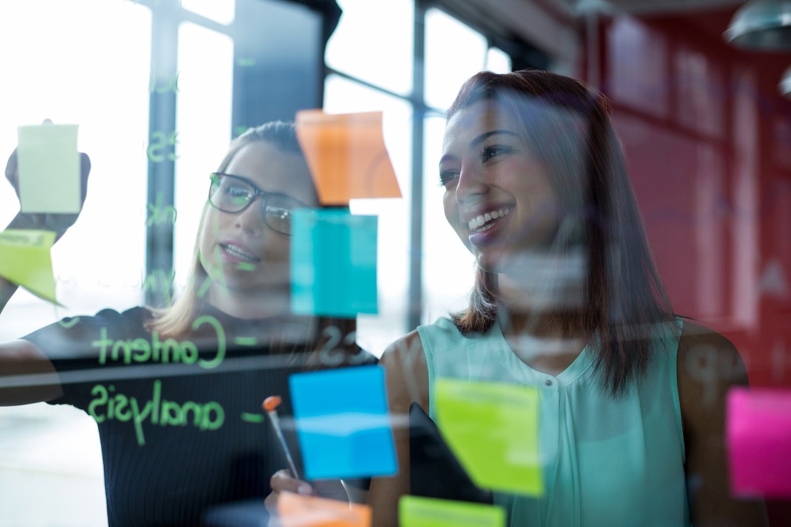 detacon IT-Sicherheitsteam plant Strategien mit Haftnotizen an einer Glaswand.