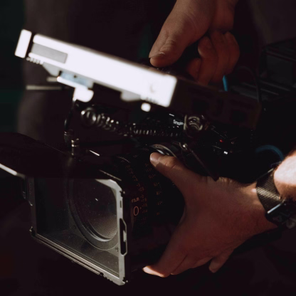 Camera monitor displaying video of a man sitting and wearing a white Diamond t-shirt and cap.