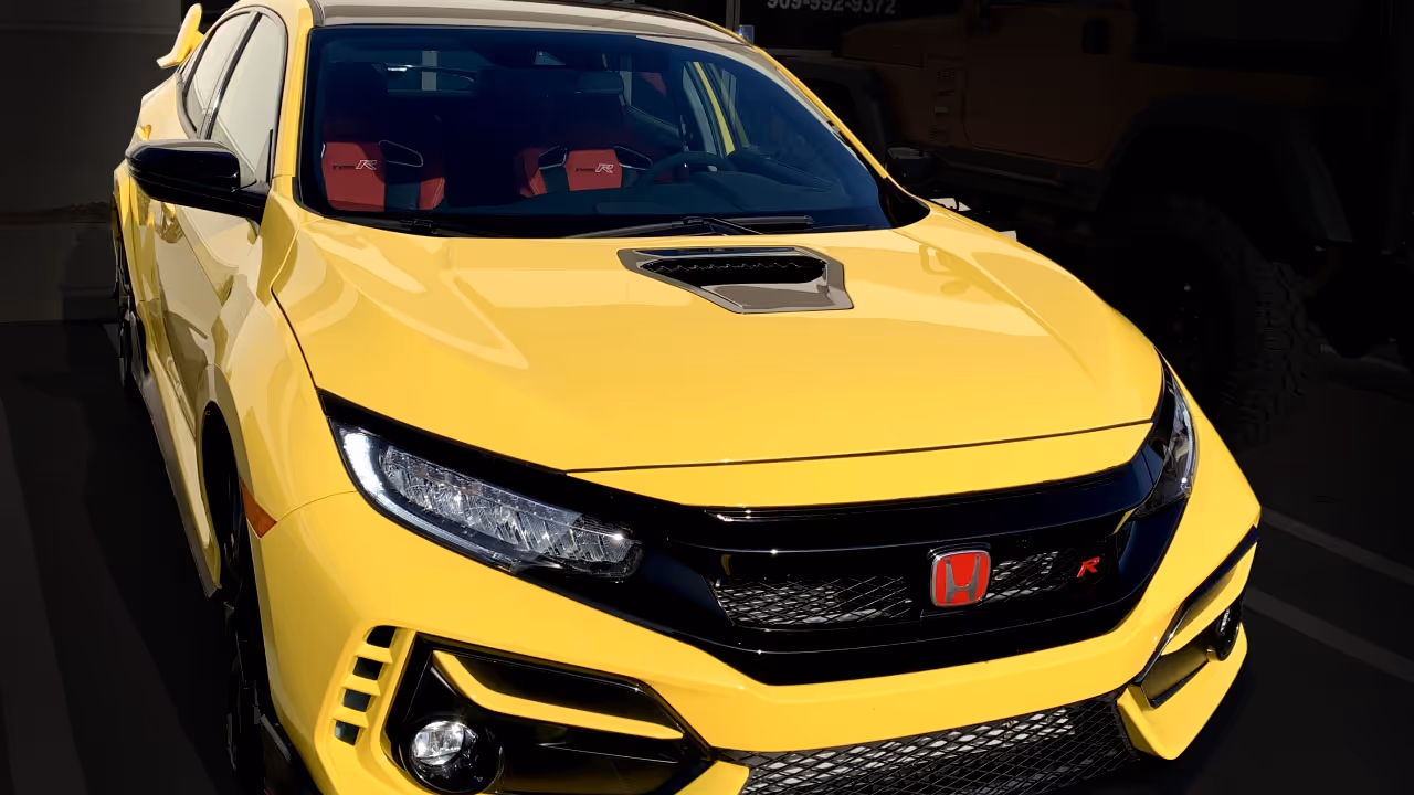 A yellow car with a chrome delete.