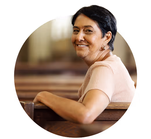 Smiling bald priest in black clerical shirt using a smartphone with a green fish symbol behind him.