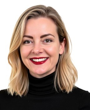 Smiling woman with blonde shoulder-length hair wearing a black turtleneck sweater.