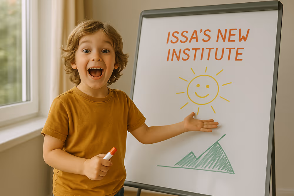 Young boy with curly hair excitedly pointing to a whiteboard that says 'Issa's New Institute' with drawings of a smiling sun and green mountains.