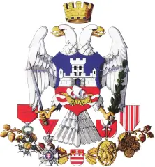 Heraldic eagle with a crown and shield featuring a castle, swords, and various medals and decorations.
