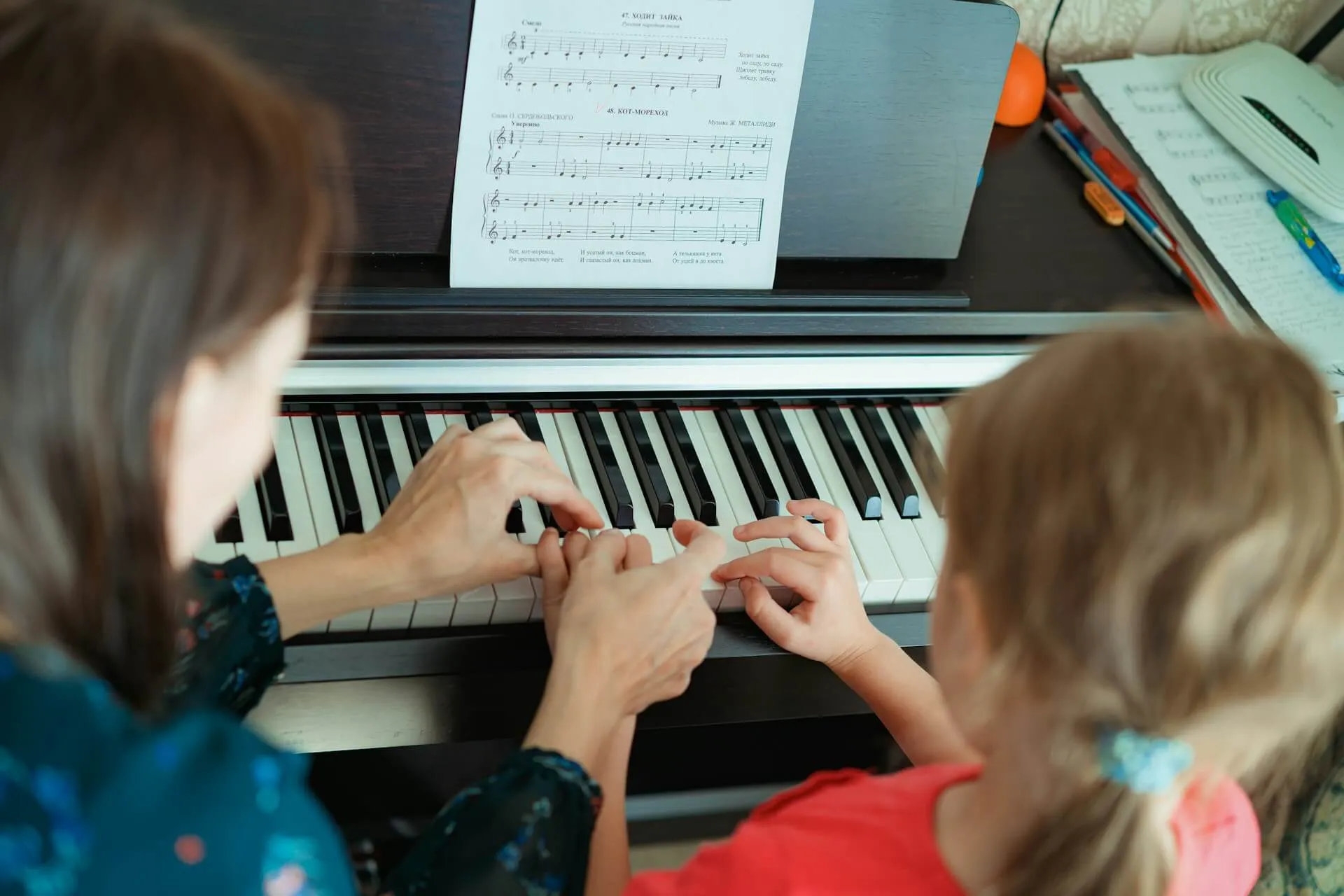 A child being guided in piano lesson