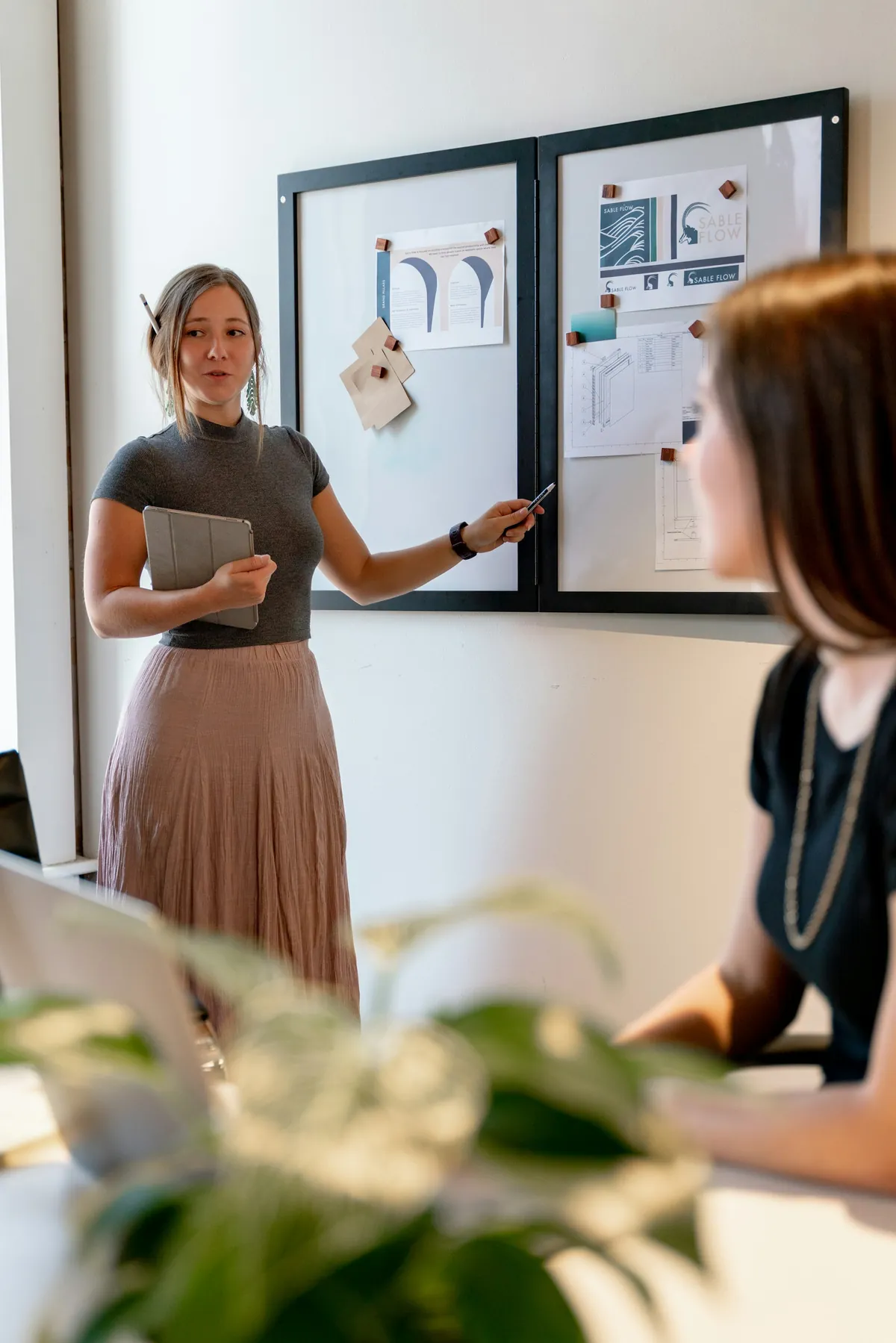 A colleague presenting a plan on a board to a teammate