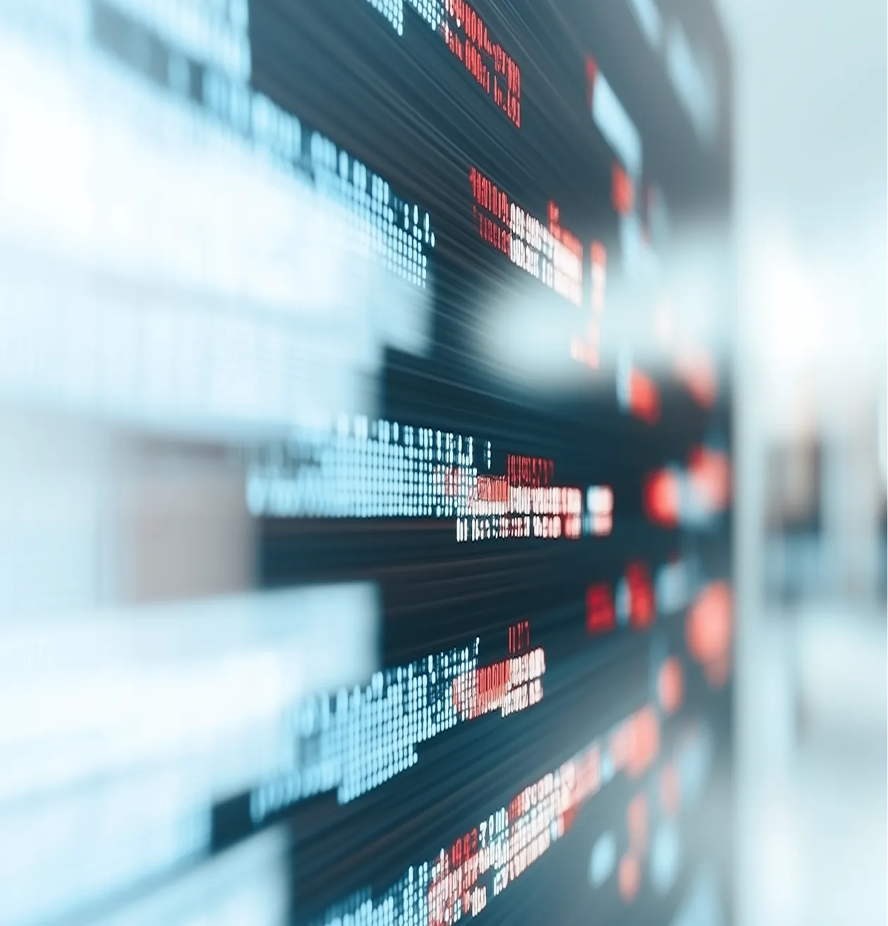 Blurred close-up of digital data and code displayed on a screen with blue and red characters.