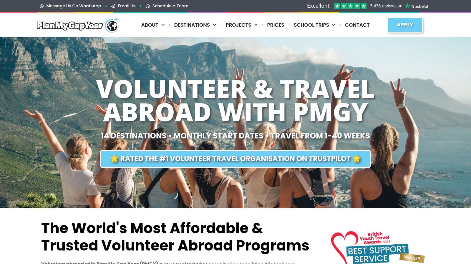 A volunteer smiles while interacting with children in a classroom setting.