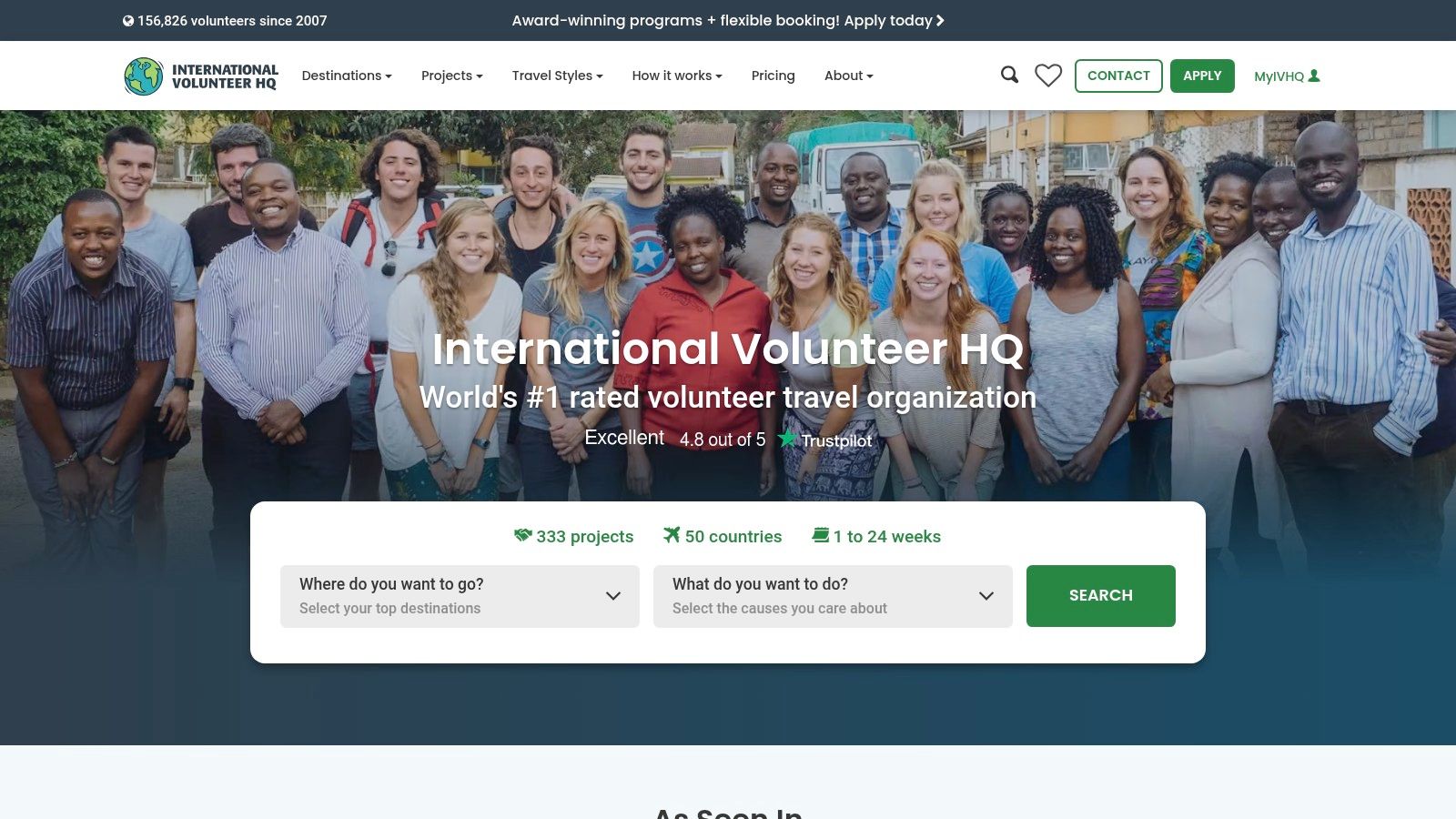 A group of volunteers smiling and working together on a construction project.