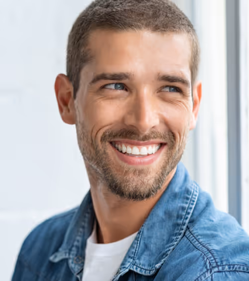 Portrait of a smiling man with short hair representing patient wellness and health optimization.