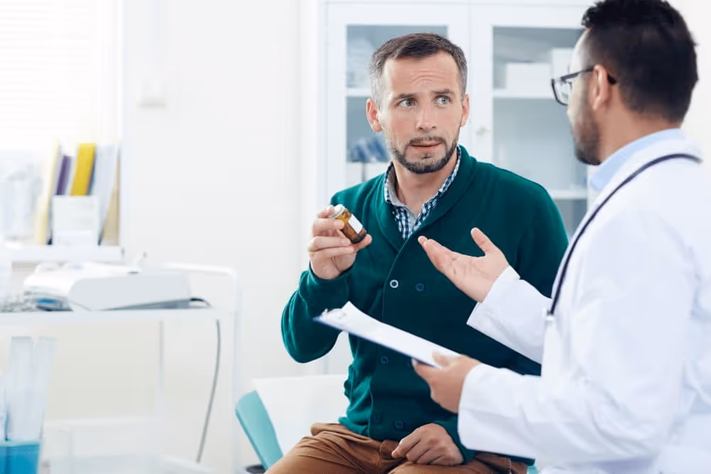 Urologist explaining a medical report to a male patient during a clinical office visit.