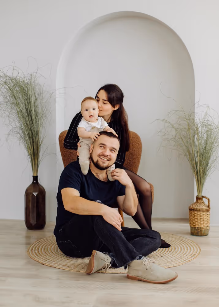 Couple sitting on the floor with their young child representing family and fertility outcomes.