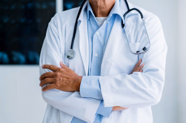 Male Urologist standing in office with arms crossed