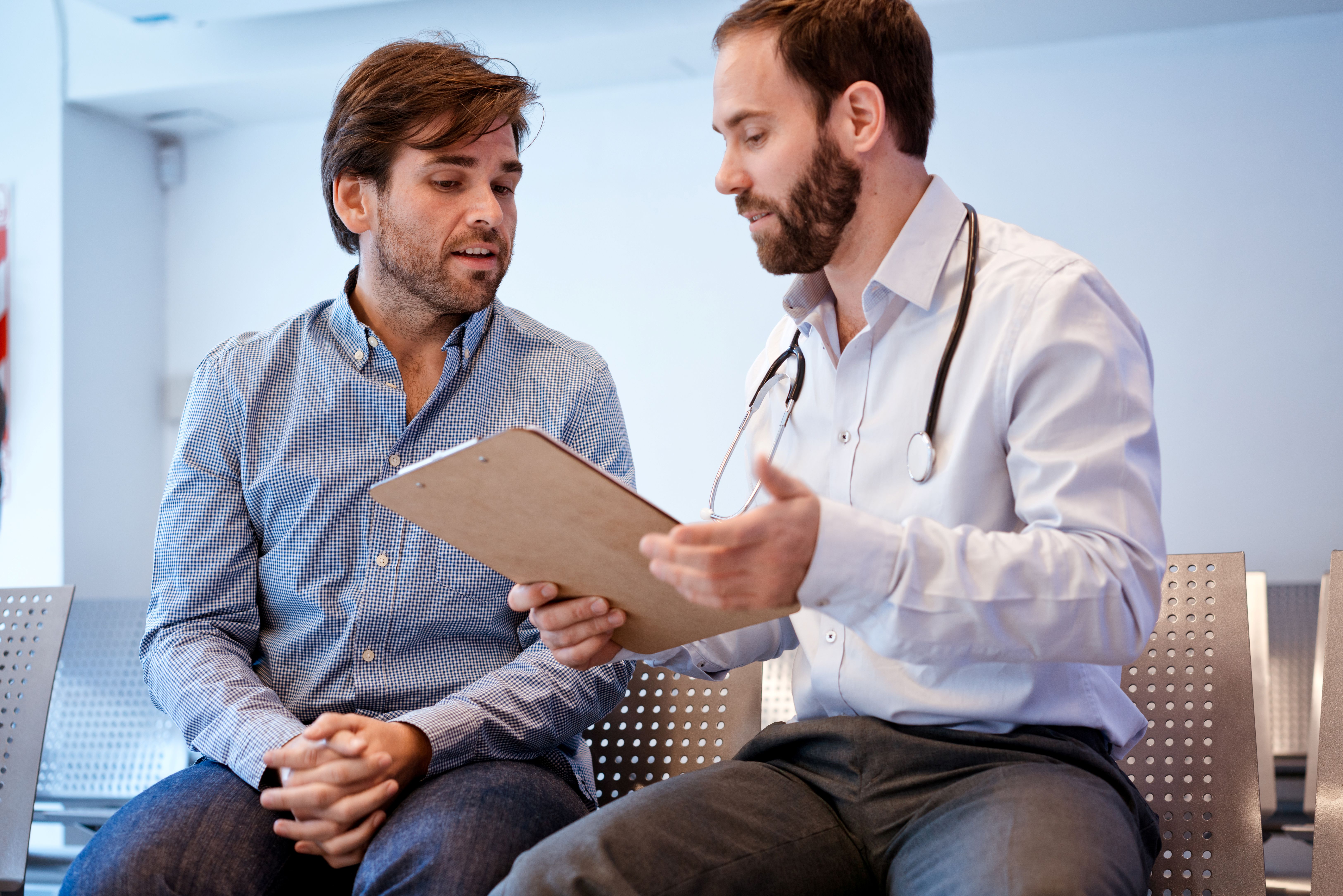 Urologist sitting with patient going over analysis and next steps
