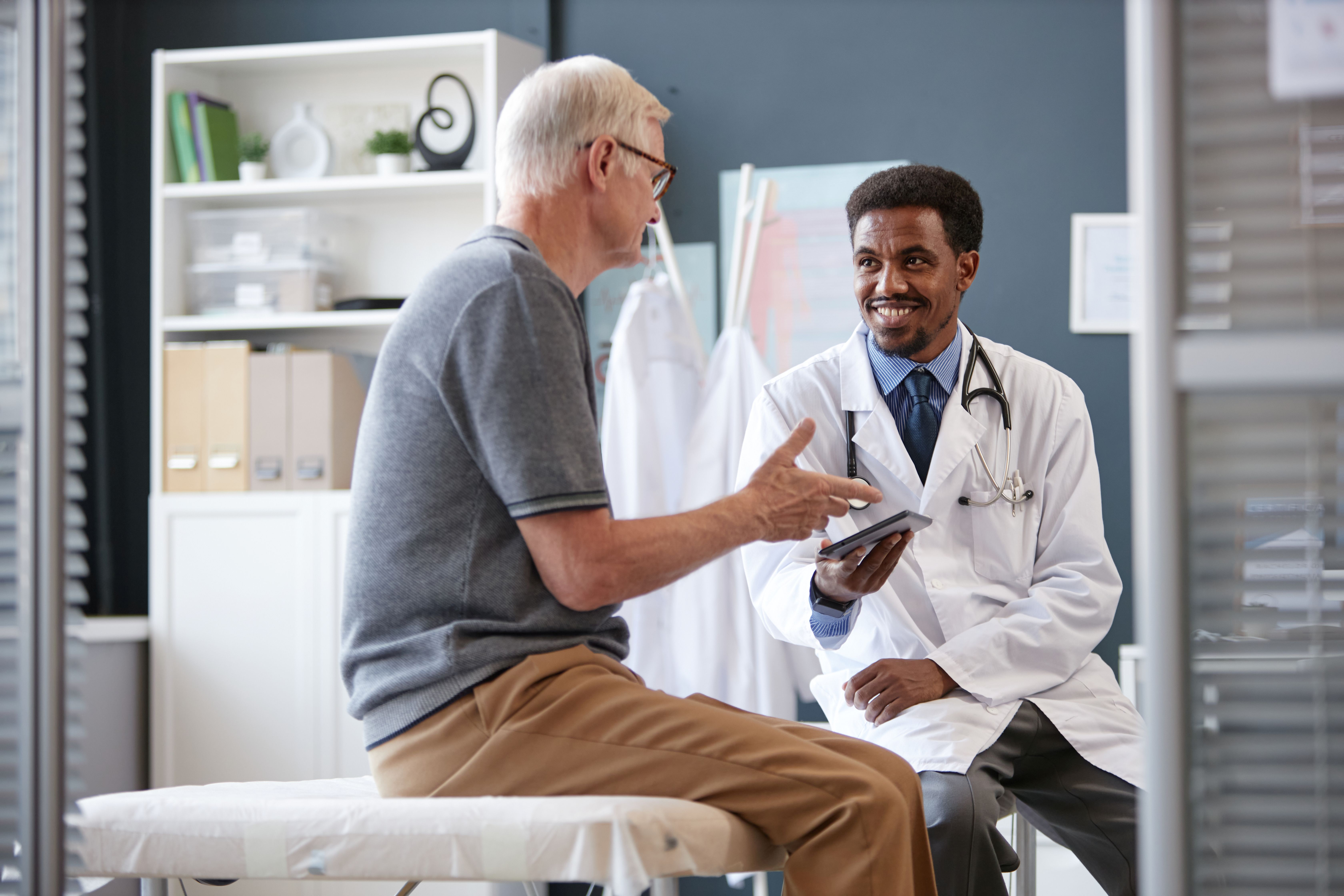Male sitting in urologist office with doctor discussing next steps 