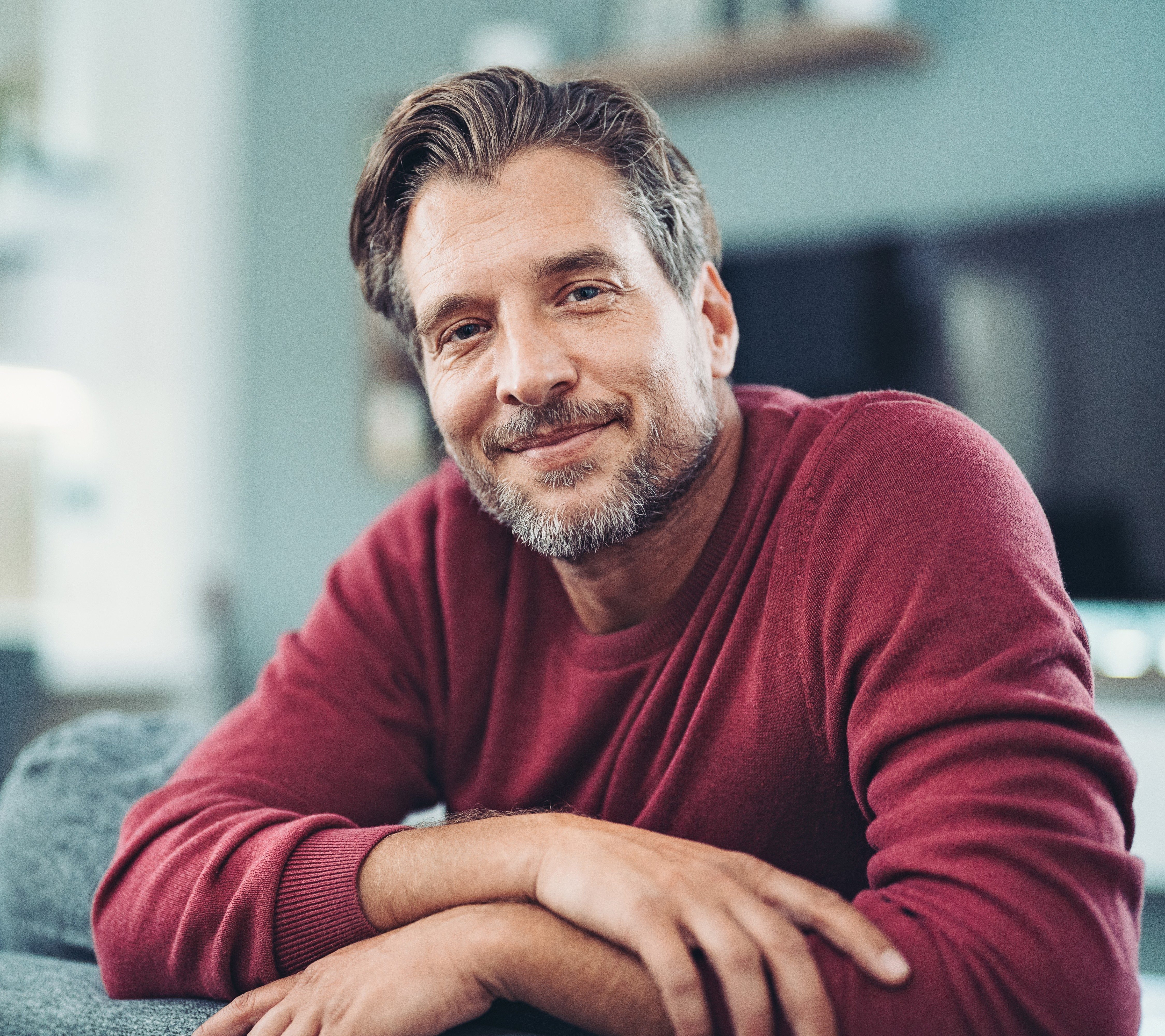 Male sitting on the couch smiling 