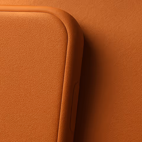 Close-up of a rounded corner of a brown leather phone case with textured surface.