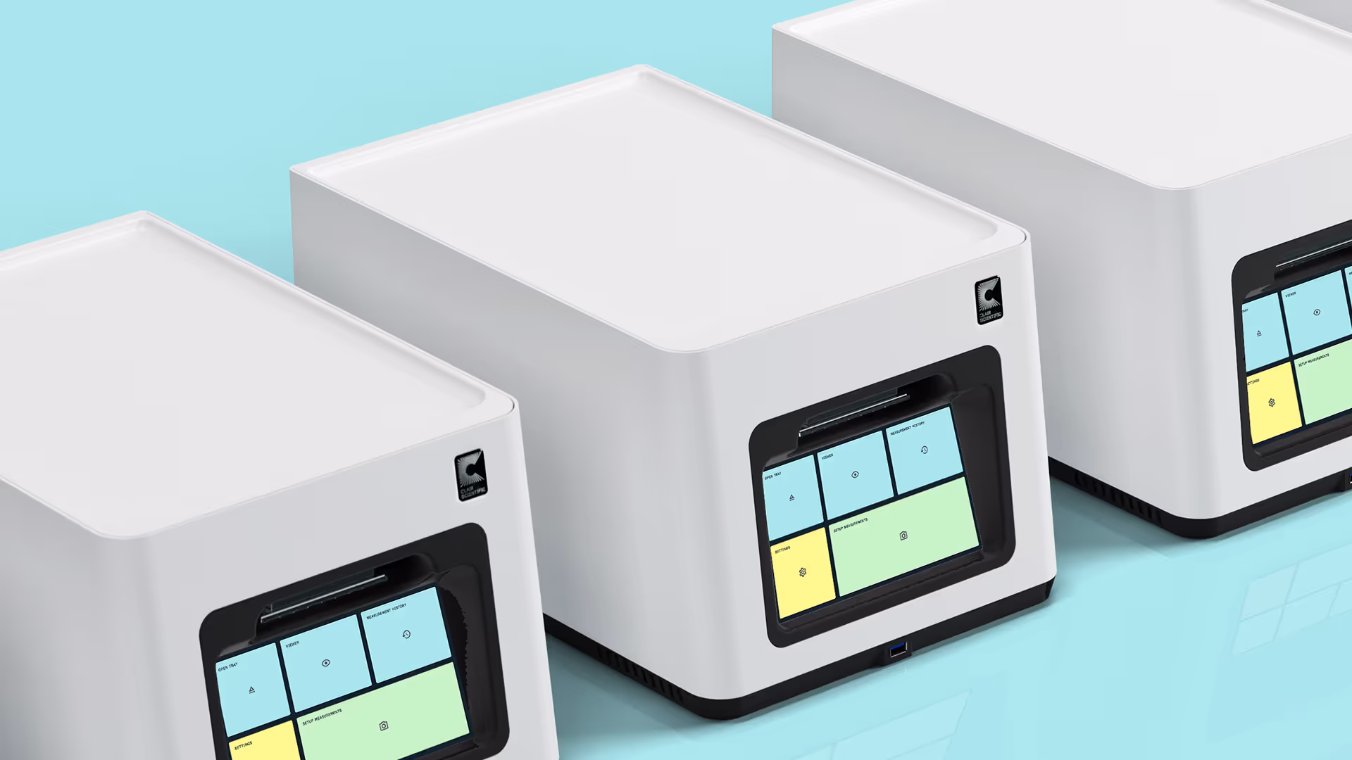 Three white CubiScientific devices with touchscreen interfaces showing blue and yellow panels on a light blue surface.