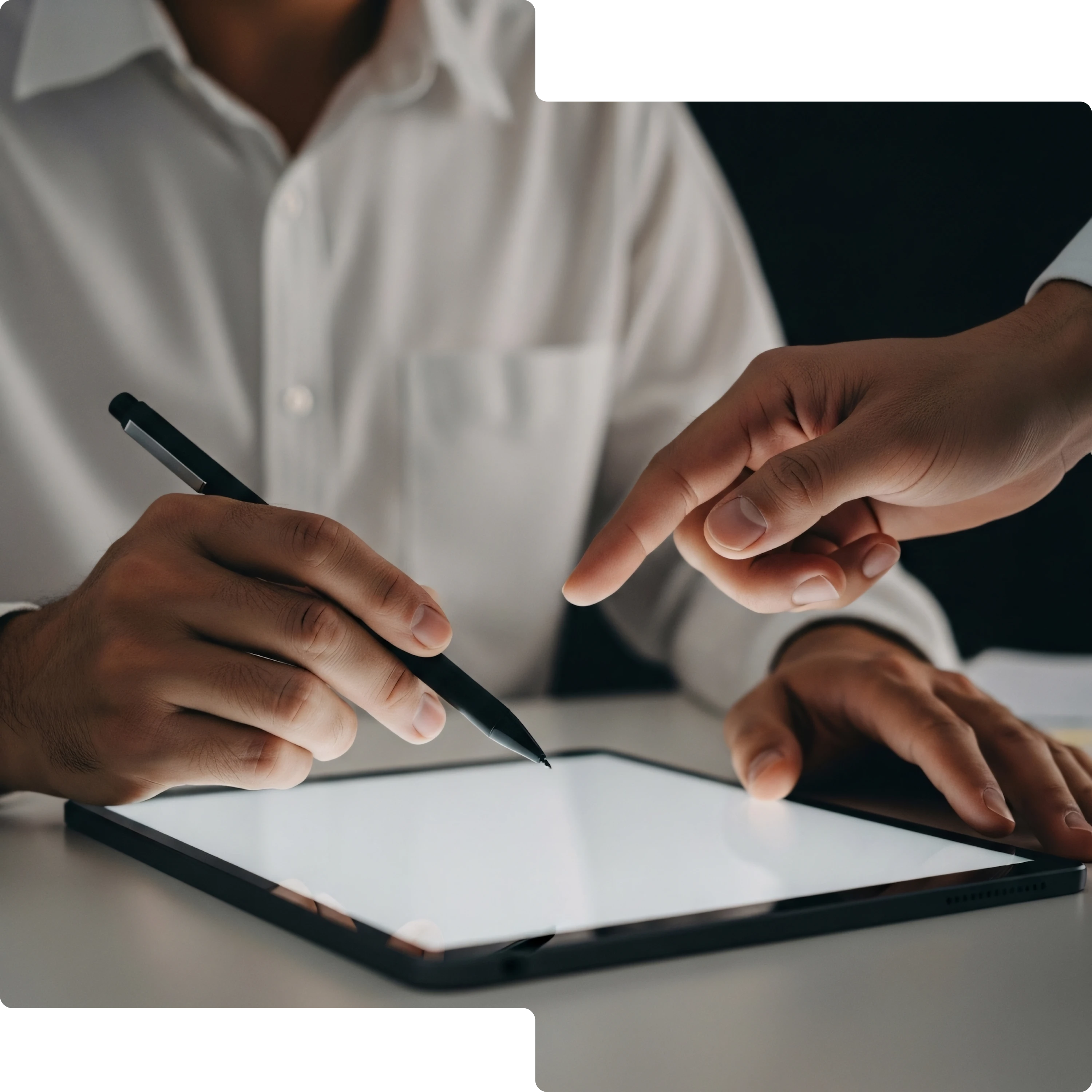 Two people interacting with a digital tablet, one holding a stylus and the other pointing at the screen.