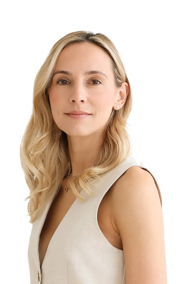 Portrait of Emily with blonde wavy hair wearing a sleeveless beige vest.