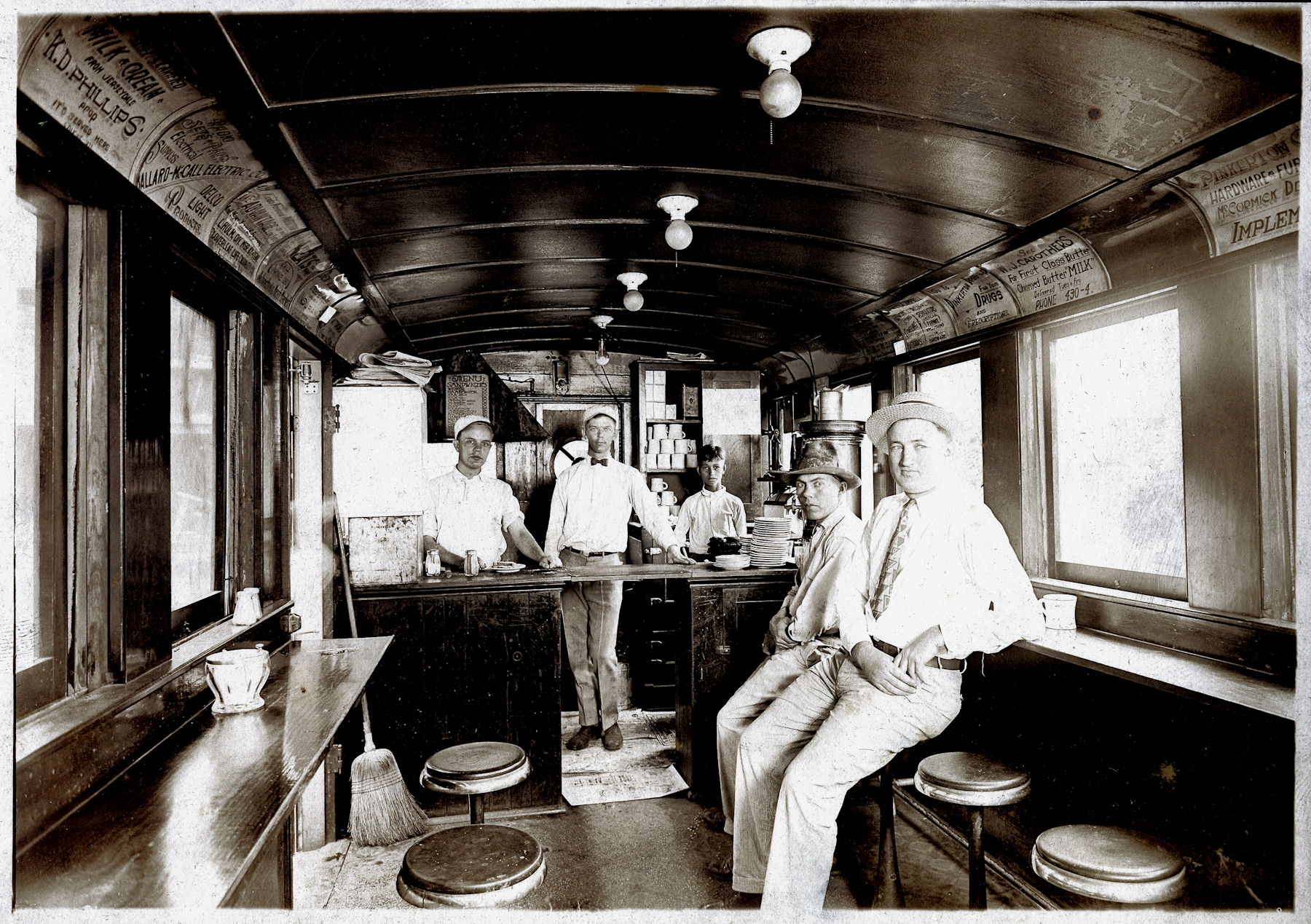 Unretouched photo. Chapman Pie Wagon interior c1920. Made from an old railroad car, the pie wagon has rows of round stools down each wall and the serving counter is at one of the narrow ends of the car.