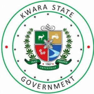 Seal of Kwara State Government featuring a shield with symbols of a deer, tractor, crops, and river, encircled by stars and the text Kwara State Government.
