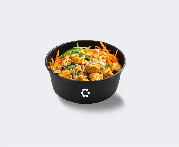 A black bowl with green soup topped with croutons and herbs, featuring a white Circus icon on the front.