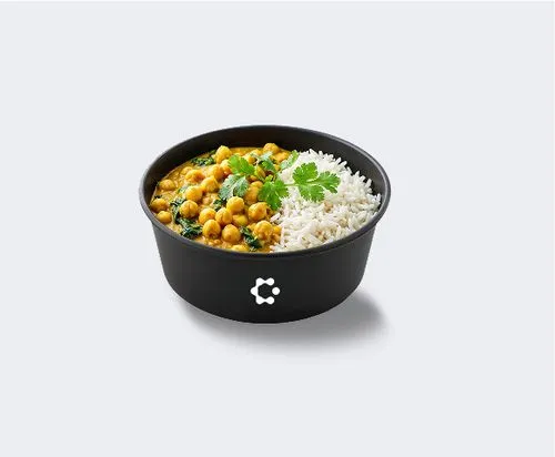 A black bowl with green soup topped with croutons and herbs, featuring a white Circus icon on the front.